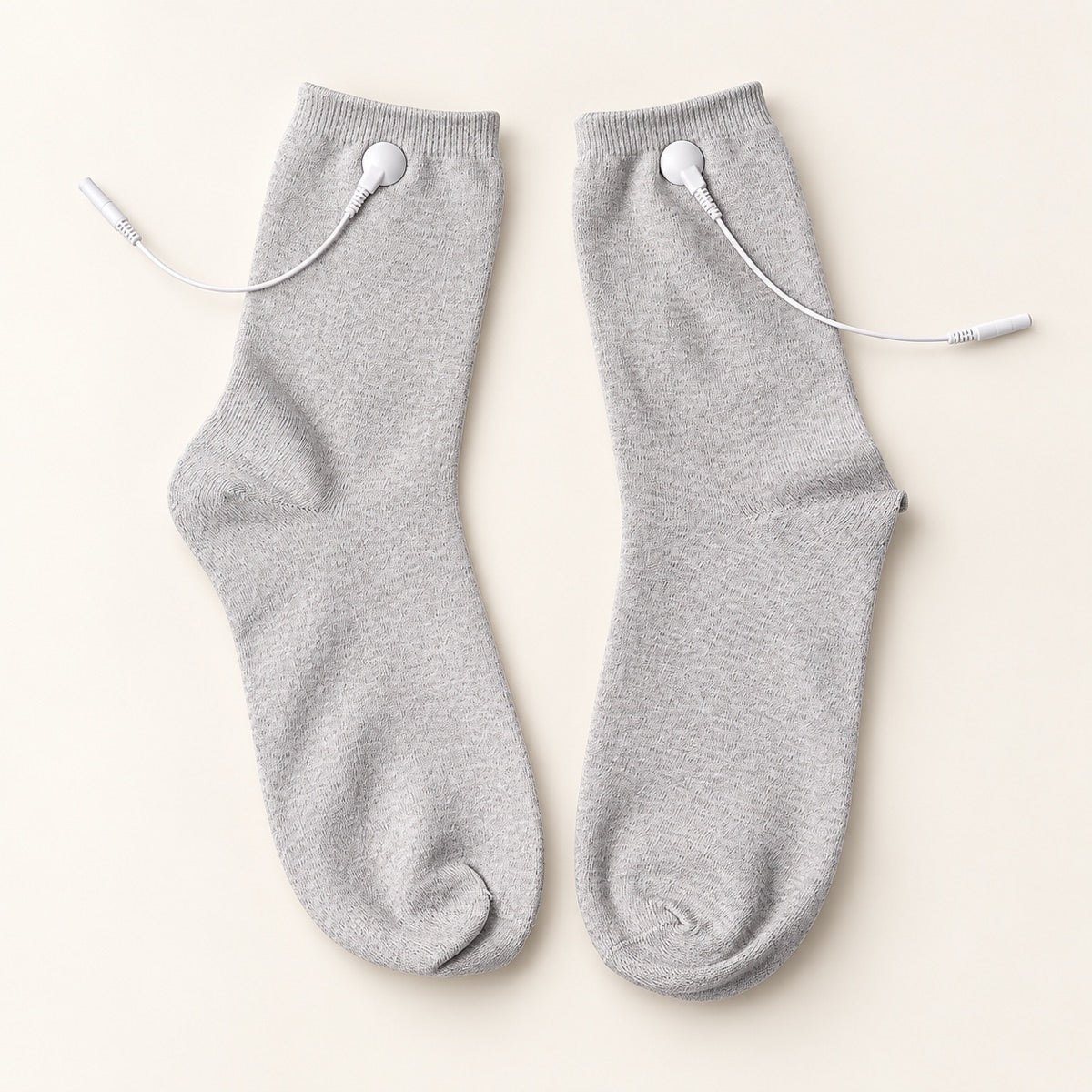 TENS therapy socks — a pair laid flat showing silver fibre fabric and snap connectors