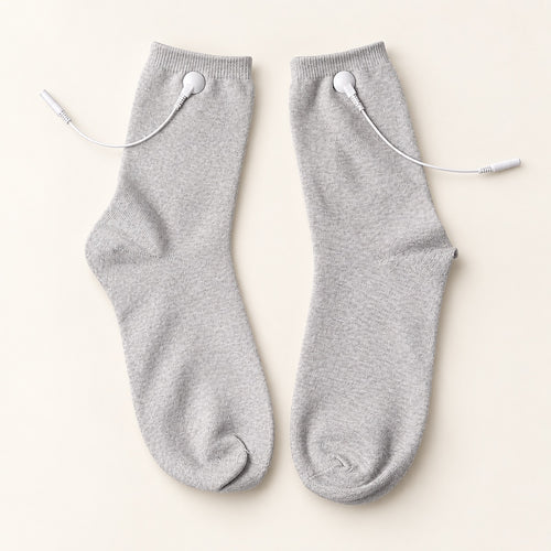 TENS therapy socks — a pair laid flat showing silver fibre fabric and snap connectors